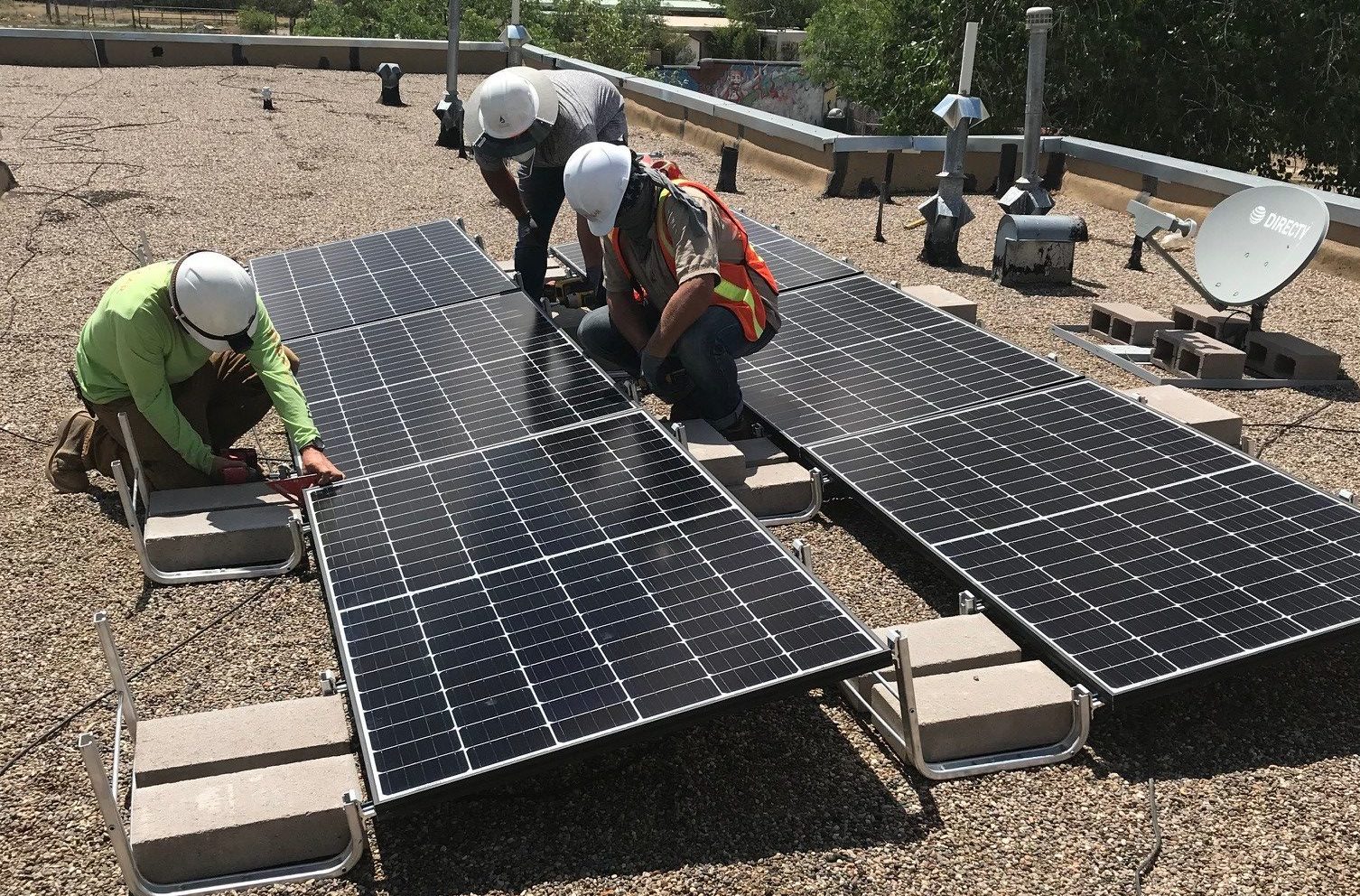 Three people installing solar.